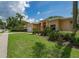 Landscaped front yard with mature plants and trees, leading to a single-story home with a two-car garage at 2406 Dana Dr, Safety Harbor, FL 34695