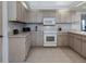 Cozy kitchen with tile backsplash, modern appliances, and light wood cabinets at 2406 Dana Dr, Safety Harbor, FL 34695