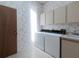 Well-lit laundry room features a washer, dryer, utility sink, and upper cabinets for storage at 2406 Dana Dr, Safety Harbor, FL 34695