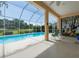 Screened-in pool area with ample seating and clear views of the surrounding landscape at 2406 Dana Dr, Safety Harbor, FL 34695