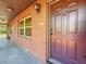 Exterior shot of the front entrance showing a brick facade and a maroon entry door at 2442 Enterprise Rd # 6, Clearwater, FL 33763