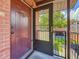 Exterior view of the front door with security screen and a glimpse of the outdoor landscape at 2442 Enterprise Rd # 6, Clearwater, FL 33763