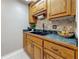 Kitchen with wood cabinets, black countertops, tile backsplash, and stainless steel appliances enhancing the kitchen's appeal at 2442 Enterprise Rd # 6, Clearwater, FL 33763