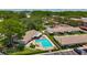 Aerial view of community pool area with lounge chairs, a shuffleboard court, and well-maintained landscaping at 2442 Enterprise Rd # 6, Clearwater, FL 33763