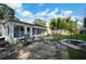 Charming backyard with lush lawn, patio, outdoor dining set, swing, and surrounded by mature trees and landscaping at 2817 Rustic Oaks Dr, Palm Harbor, FL 34684