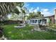 Inviting backyard with a fire pit, patio, lush lawn, swing, and mature trees that provide privacy and shade at 2817 Rustic Oaks Dr, Palm Harbor, FL 34684