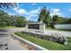 Community sign for Rustic Oaks deed-restricted community, with stone base and manicured landscaping at 2817 Rustic Oaks Dr, Palm Harbor, FL 34684