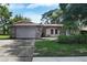 Charming single-story home with a two-car garage and unique stone accent entryway at 2817 Rustic Oaks Dr, Palm Harbor, FL 34684