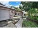 Charming home exterior featuring stone archway, well-manicured landscaping and walkway, and a two car garage at 2817 Rustic Oaks Dr, Palm Harbor, FL 34684