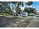 Home exterior with mature trees providing privacy and shade, as well as a PODS moving and storage container at 2817 Rustic Oaks Dr, Palm Harbor, FL 34684