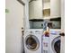 Functional laundry room equipped with a washer, dryer, and ample storage cabinets at 2817 Rustic Oaks Dr, Palm Harbor, FL 34684