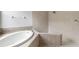 This bathroom features a soaking tub, tile surround, and tiled walk-in shower at 3013 Silvermill Loop # O, Land O Lakes, FL 34638