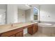 Bright bathroom featuring dual sinks, a tub, and an oversized mirror at 3013 Silvermill Loop # O, Land O Lakes, FL 34638