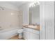 Bathroom featuring a vanity, toilet, and bathtub with a tiled shower, with ample lighting at 3013 Silvermill Loop # O, Land O Lakes, FL 34638