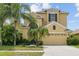 Stunning two-story home featuring a lush, landscaped yard with tropical palm trees at 3013 Silvermill Loop # O, Land O Lakes, FL 34638