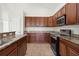 Close-up shot of kitchen with stainless steel appliances and wood cabinetry at 3013 Silvermill Loop # O, Land O Lakes, FL 34638