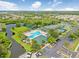 Aerial view featuring a pool, playground, tennis courts, and tranquil pond at 30247 Emmetts Ct, Wesley Chapel, FL 33543