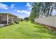 Spacious backyard with a lush green lawn, a privacy fence, and a screened patio at 30247 Emmetts Ct, Wesley Chapel, FL 33543