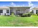 Backyard view featuring a screened patio with a home and lush lawn at 30247 Emmetts Ct, Wesley Chapel, FL 33543