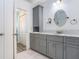Bathroom with granite countertop, gray vanity, and decorative oval mirror at 30247 Emmetts Ct, Wesley Chapel, FL 33543
