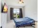 Simple bedroom with a ceiling fan and large window for natural light at 30247 Emmetts Ct, Wesley Chapel, FL 33543