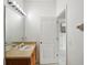 Bright bathroom featuring a spacious vanity, large mirror, and an open doorway at 30352 Elderwood Dr, Wesley Chapel, FL 33543