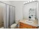 Cozy bathroom featuring a shower with striped curtain and a vanity with a neutral countertop at 30352 Elderwood Dr, Wesley Chapel, FL 33543
