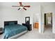Bedroom with ceiling fan, dresser and ensuite bath at 30352 Elderwood Dr, Wesley Chapel, FL 33543