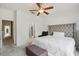 Comfortable bedroom with neutral tones, a ceiling fan, and a glimpse into the en-suite bathroom at 30352 Elderwood Dr, Wesley Chapel, FL 33543