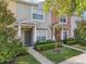 Townhome with well-maintained front lawn and attractive exterior paint colors with manicured bushes at 30352 Elderwood Dr, Wesley Chapel, FL 33543