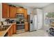 Well-equipped kitchen featuring stainless steel appliances, wooden cabinets, and ample counter space at 30352 Elderwood Dr, Wesley Chapel, FL 33543