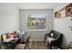 Home office with a desk and dark leather couch under a large window at 30352 Elderwood Dr, Wesley Chapel, FL 33543