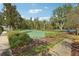 Well-maintained tennis court surrounded by lush greenery and landscaping at 30352 Elderwood Dr, Wesley Chapel, FL 33543