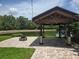 Backyard gazebo with a firepit and a serene pond in the background at 31141 Harthorn Ct, Wesley Chapel, FL 33543