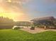 Backyard gazebo with a firepit overlooking the lake at sunset at 31141 Harthorn Ct, Wesley Chapel, FL 33543