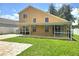 A large backyard with a lawn, patio, and an exterior elevation of the house at 31141 Harthorn Ct, Wesley Chapel, FL 33543