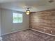 Cozy bedroom with a window overlooking a lake, wood accent wall, and carpeted floors at 31141 Harthorn Ct, Wesley Chapel, FL 33543
