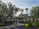 Exterior shot of a community clubhouse featuring lush landscaping and palm trees at 31141 Harthorn Ct, Wesley Chapel, FL 33543