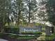 Community entrance sign set amongst lush landscaping and mature oak trees at 31141 Harthorn Ct, Wesley Chapel, FL 33543
