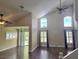 Spacious living room with high ceilings, large windows, wood floors, and ceiling fans at 31141 Harthorn Ct, Wesley Chapel, FL 33543