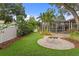 Secluded backyard with a charming firepit area, a screened lanai, and verdant landscaping at 3307 W Knights Ave, Tampa, FL 33611