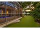 A spacious backyard features a screened-in pool, lush landscaping, and ample turf at 3307 W Knights Ave, Tampa, FL 33611