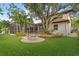 Picturesque backyard featuring a screened lanai, a built-in firepit, and lush landscaping at 3307 W Knights Ave, Tampa, FL 33611