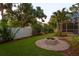 Landscaped backyard featuring a brick fire pit, putting green, and privacy fence at 3307 W Knights Ave, Tampa, FL 33611