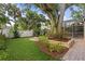 Lush backyard featuring a built-in firepit, manicured landscaping, and a screened lanai at 3307 W Knights Ave, Tampa, FL 33611