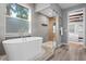 Elegant bathroom featuring a soaking tub, walk-in shower, and access to the bedroom at 3307 W Knights Ave, Tampa, FL 33611