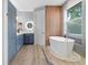 Luxury bathroom with soaker tub, wood look floors and bright blue cabinetry at 3307 W Knights Ave, Tampa, FL 33611