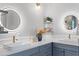 Bathroom featuring double vanity sinks, modern lighting, and blue cabinetry at 3307 W Knights Ave, Tampa, FL 33611