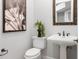 Bathroom features a pedestal sink, decorative mirror, and fixtures at 3307 W Knights Ave, Tampa, FL 33611