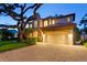 Well-lit exterior of a two-story home with paver driveway at 3307 W Knights Ave, Tampa, FL 33611